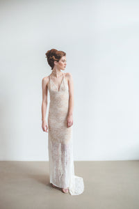 A different wedding dress made from lace with an open back and long train.