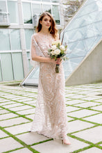 Load image into Gallery viewer, Modern Bride in chic embroidered lace wedding dress walking with flowers, smiling.