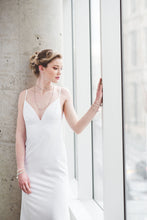 Load image into Gallery viewer, A fitted crepe wedding gown with open back and lace up straps.