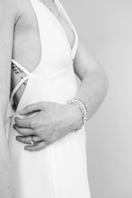 Load image into Gallery viewer, A low cut crepe wedding dress with side slit and long train.