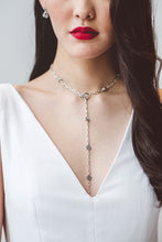Load image into Gallery viewer, A close up of a bride wearing a chic white wedding dress with low V neckline.