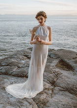 Load image into Gallery viewer, Bride holding flowers with backless sheath wedding dress and short train in Vancouver.