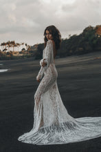 Load image into Gallery viewer, Model standing on beach with her profile showing backless feature of beaded Vancouver wedding dress.