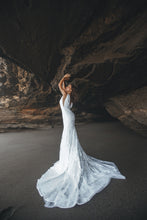 Load image into Gallery viewer, Bride in cave with arms up wearing a boho fit-and-flare lace wedding dress.
