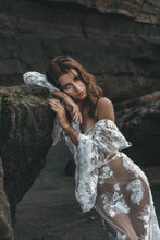 Load image into Gallery viewer, Sexy pose of model showing shoulder leaning against rock in lace wedding dress.
