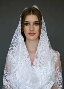 Model close-up in bridal veil and lace jacket.
