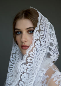 Close up of side of face, model wearing bridal veil and bolero.