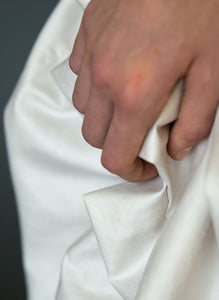 Detail of fabric and hand of silk draped Grecian wedding dress.