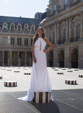 Load image into Gallery viewer, Bride posing on art in Paris, facing us, in open back halter top bridal gown.
