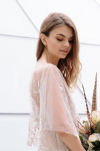 Load image into Gallery viewer, Profile of vancouver bride in flutter sleeve lace dress, looking down while holding flowers.
