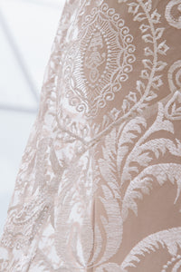Close up shot of lace at back hip of gown. Showcasing that the sheath slip is tighter than the lace overlay.