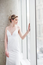 Load image into Gallery viewer, A fitted crepe wedding gown with open back and lace up straps. 
