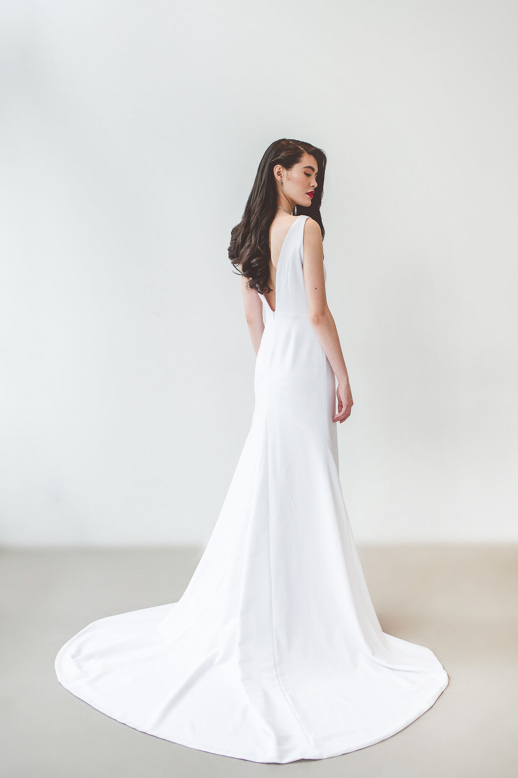 A unique backless minimalist wedding dress with long train handmade in Vancouver.
