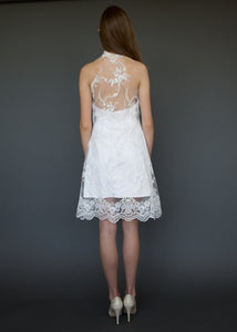 Model facing away, wearing low back with lace short wedding dress.