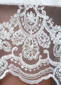 Detail of lace hem of short modern wedding dress from Vancouver wedding dress shops.