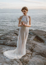 Load image into Gallery viewer, Bride holding flowers with backless sheath wedding dress and short train in Vancouver.
