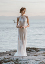 Load image into Gallery viewer, Bride standing on rock wearing halter wedding dress.
