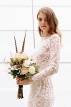 Load image into Gallery viewer, Bride with flowers wearing long sleeve lace wedding dress in Vancouver.
