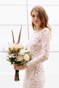 Bride with flowers wearing long sleeve lace wedding dress in Vancouver.