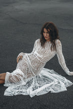 Load image into Gallery viewer, Vancouver bride lying on her side on beach in long sleeve beaded couture wedding dress.

